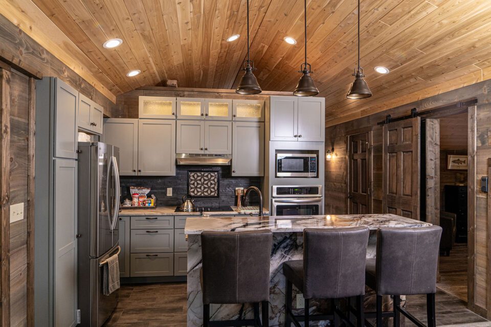 This home features both rustic log paneling mixed with a contemporary kitchen design.